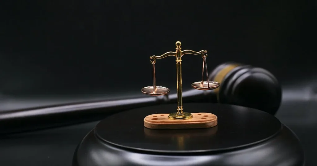Miniatura da balança da justiça sobre um martelo de juiz, representando o direito à indenização por dano moral.