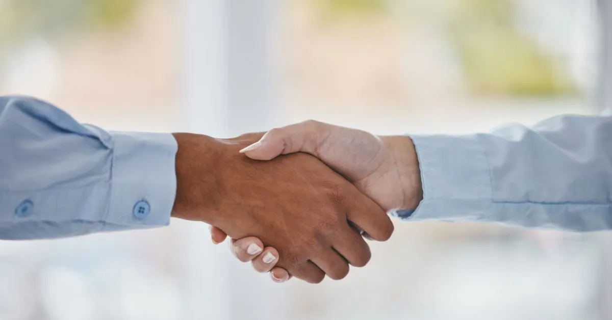 Aperto de mãos simbolizando um acordo justo entre consumidor e fornecedor, representando os direitos do consumidor.