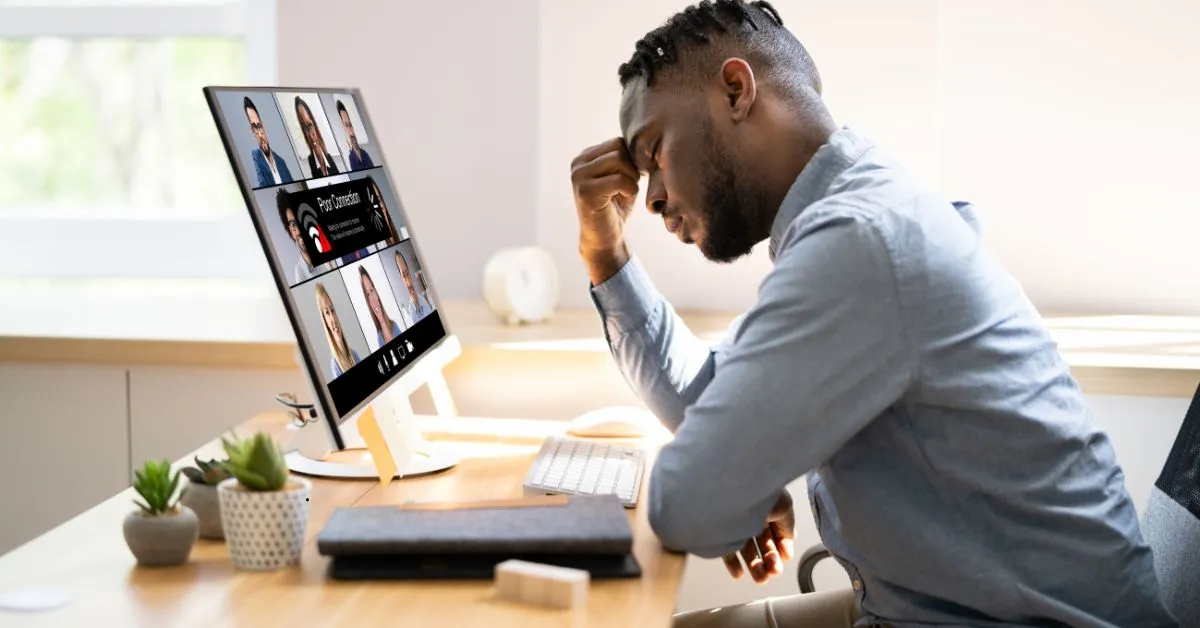 Homem frustrado com queda de conexão durante reunião online, simbolizando falhas em serviços de internet