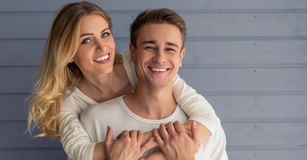 Casal jovem sorrindo com expressão de carinho e proximidade, representando a união estável e o relacionamento construído com afeto e parceria.