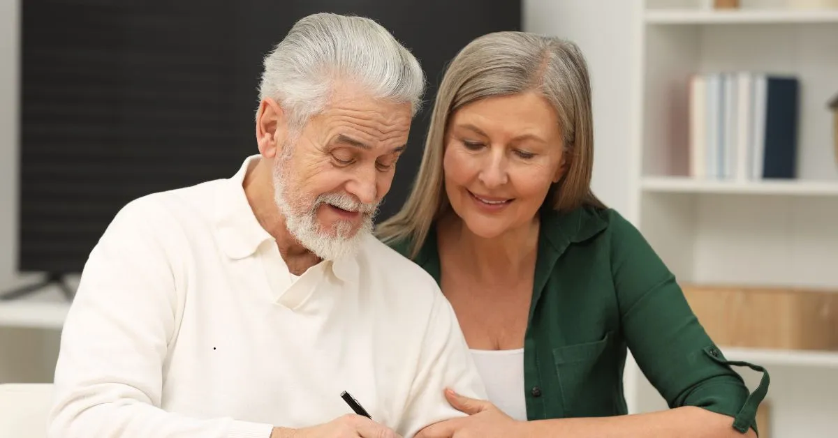 Casal de idosos assinando documento para planejar doação em vida ou testamento.