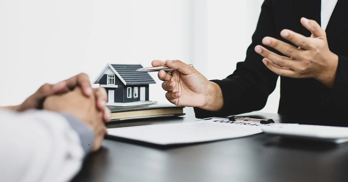 Negociação de distrato de imóvel na planta com contrato e maquete de casa sobre a mesa