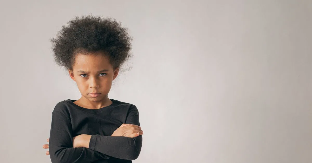 Filhos podem escolher com quem vão morar? Criança com braços cruzados e expressão séria, simbolizando conflitos de guarda e convivência