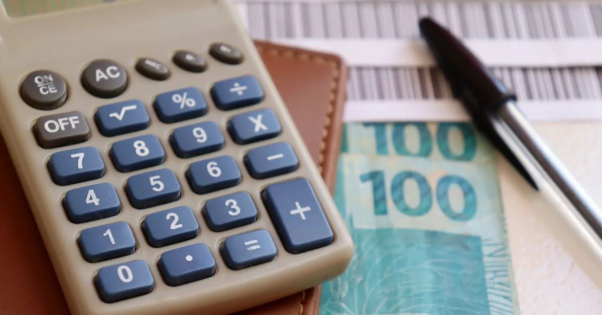 Calculadora, dinheiro e boleto bancário representando o golpe do boleto falso no Brasil
