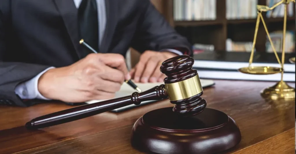 Inventário judicial: profissional do direito assinando documento com martelo e balança sobre a mesa