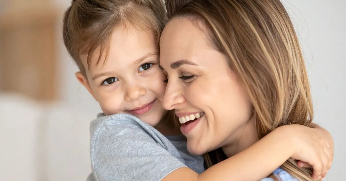 Mãe abraçando filha pequena com sorriso, simbolizando afeto e proteção na guarda compartilhada com medidas protetivas.
