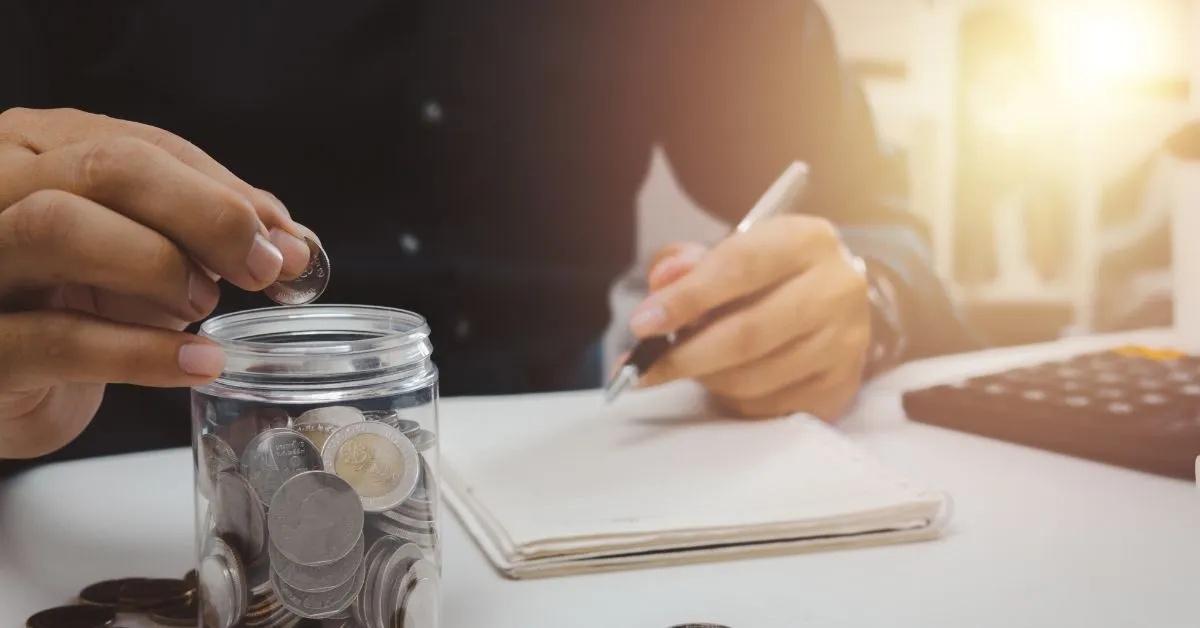 Pente-fino do INSS em 2025 ilustrado por mão colocando moeda em pote, com caderno e calculadora, sinal de revisão de benefícios