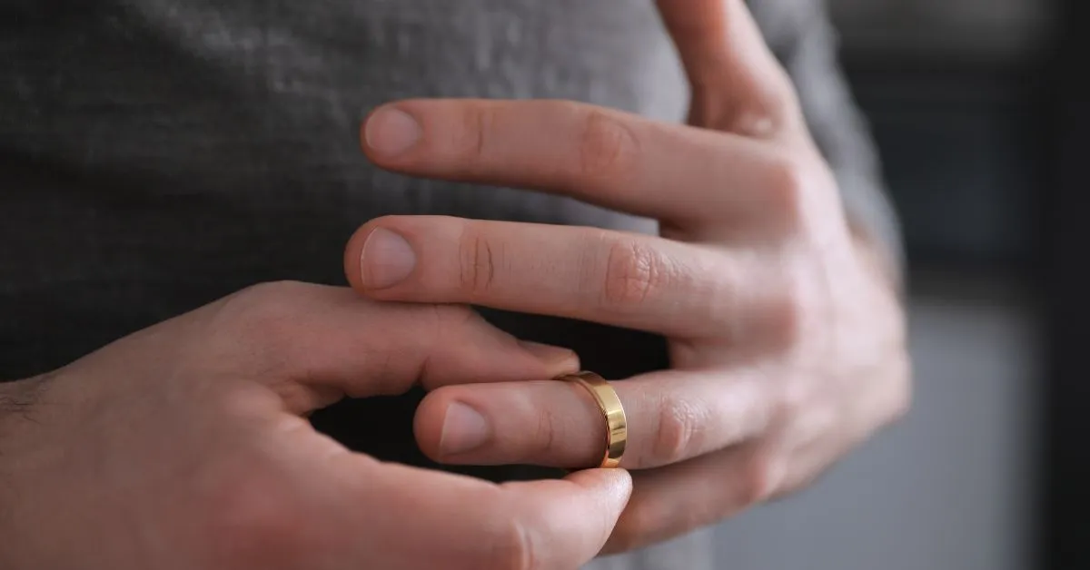Pessoa retirando aliança de casamento, simbolizando o divórcio litigioso.