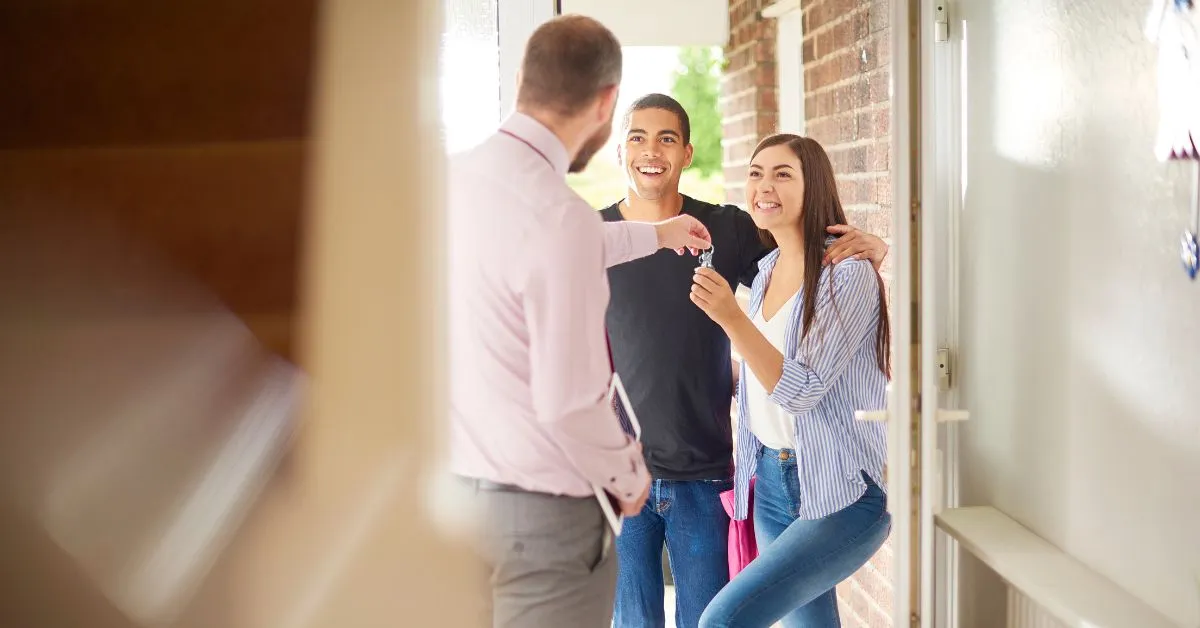 Casal recebe as chaves de um imóvel do corretor, simbolizando doação com usufruto e direito de continuar morando na casa.