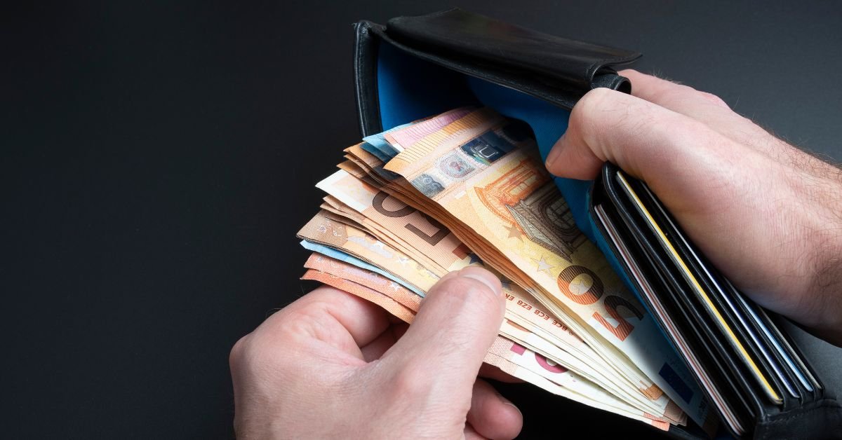 Homem segurando carteira com dinheiro representando pagamento de fiança criminal
