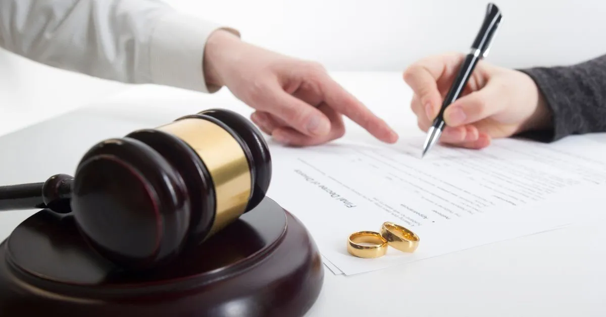 assinatura de documentos de divórcio e alianças sobre a mesa