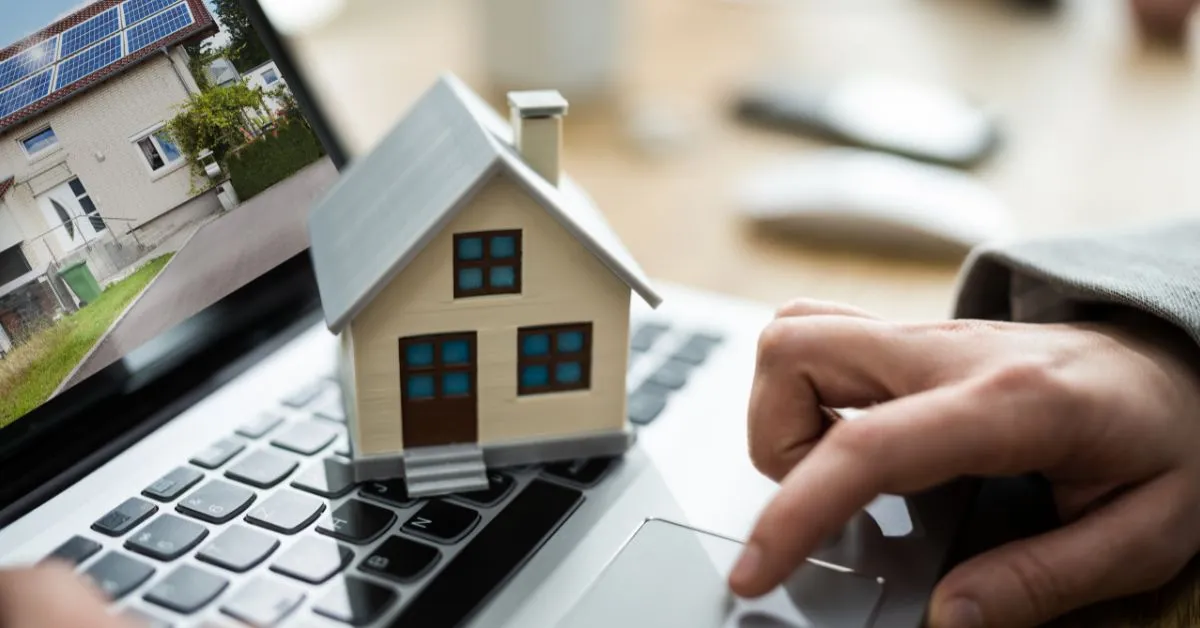 Compra de imóvel com dívida oculta de condomínio representada por casa sobre notebook durante análise de documentação imobiliária