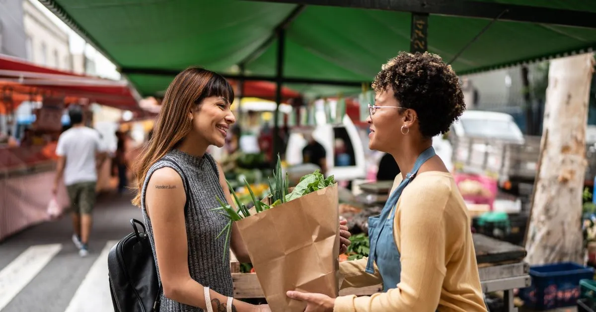 Consumidora comprando produto em feira livre e entendendo seus direitos em compras informais