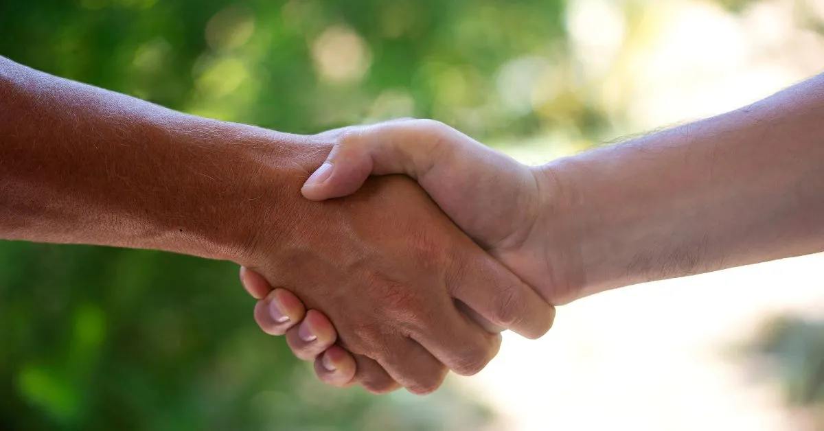 Contrato de gaveta entre comprador e vendedor representado por aperto de mãos em negociação de imóvel