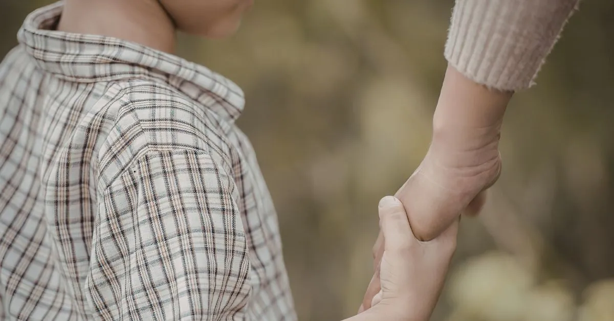 Revisão de pensão alimentícia: mãe segurando a mão de uma criança representando responsabilidade financeira e cuidado familiar